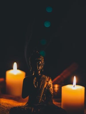 Bouddha assis à coté de bougies