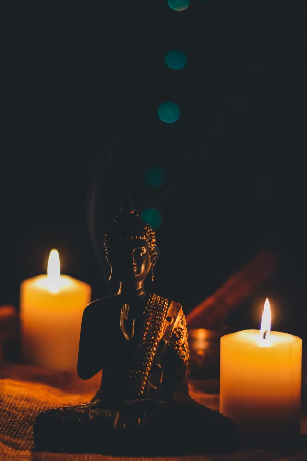Bouddha assis à coté de bougies