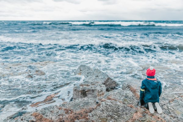 broderie diamant Un enfant assis sur un rocher regardant l'océan