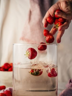 broderie diamant Une personne versant des fraises dans un verre d'eau