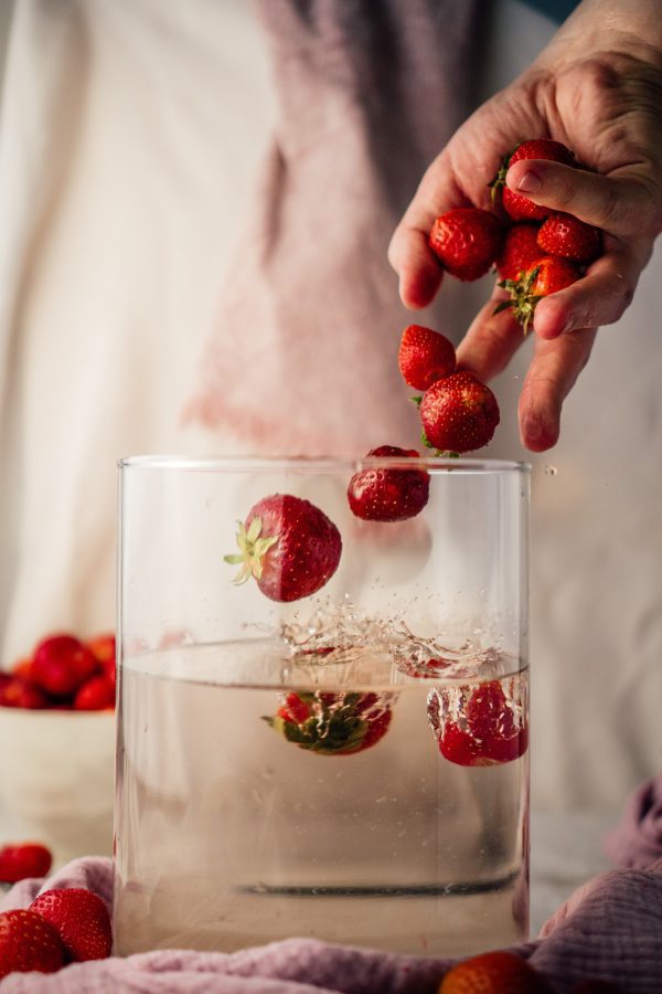 broderie diamant Une personne versant des fraises dans un verre d'eau