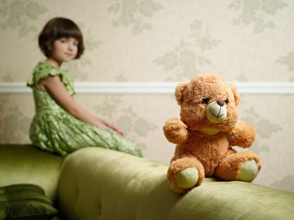 broderie diamant Une fille assise sur un canapé avec un ours en peluche
