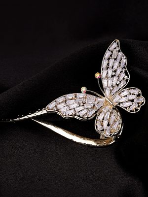 broderie diamant Une broche papillon en or sur un tissu noir