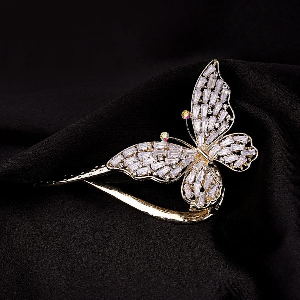broderie diamant Une broche papillon en or sur un tissu noir