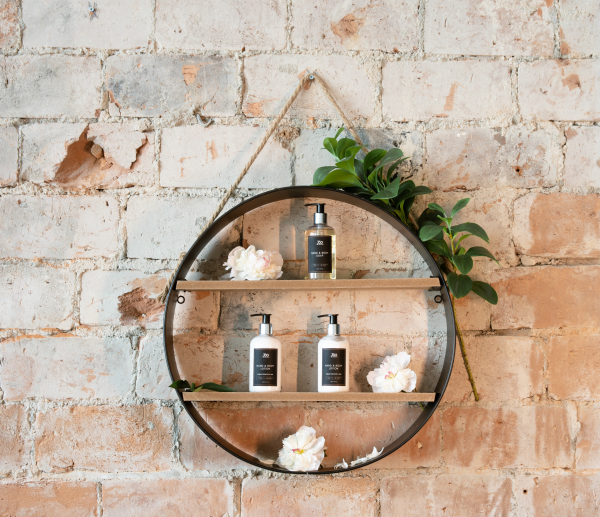 broderie diamant Une étagère circulaire avec des bouteilles et des fleurs sur un mur de briques