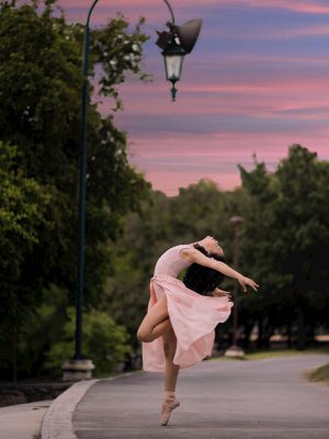 broderie diamant Une femme en robe rose dansant sur un trottoir